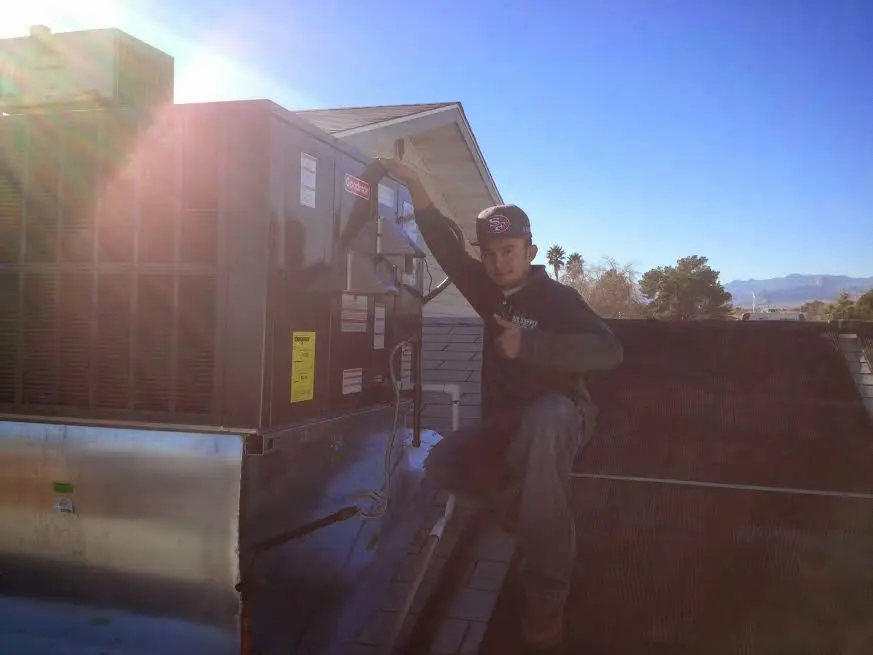 HVAC technician performing AC Tune-Up on a rooftop unit in Ankeny